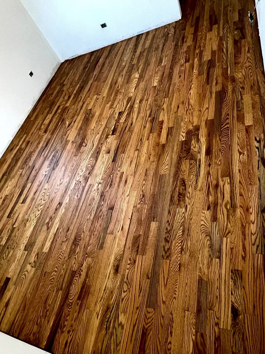 Warm honey oak hardwood planks newly installed in an empty room