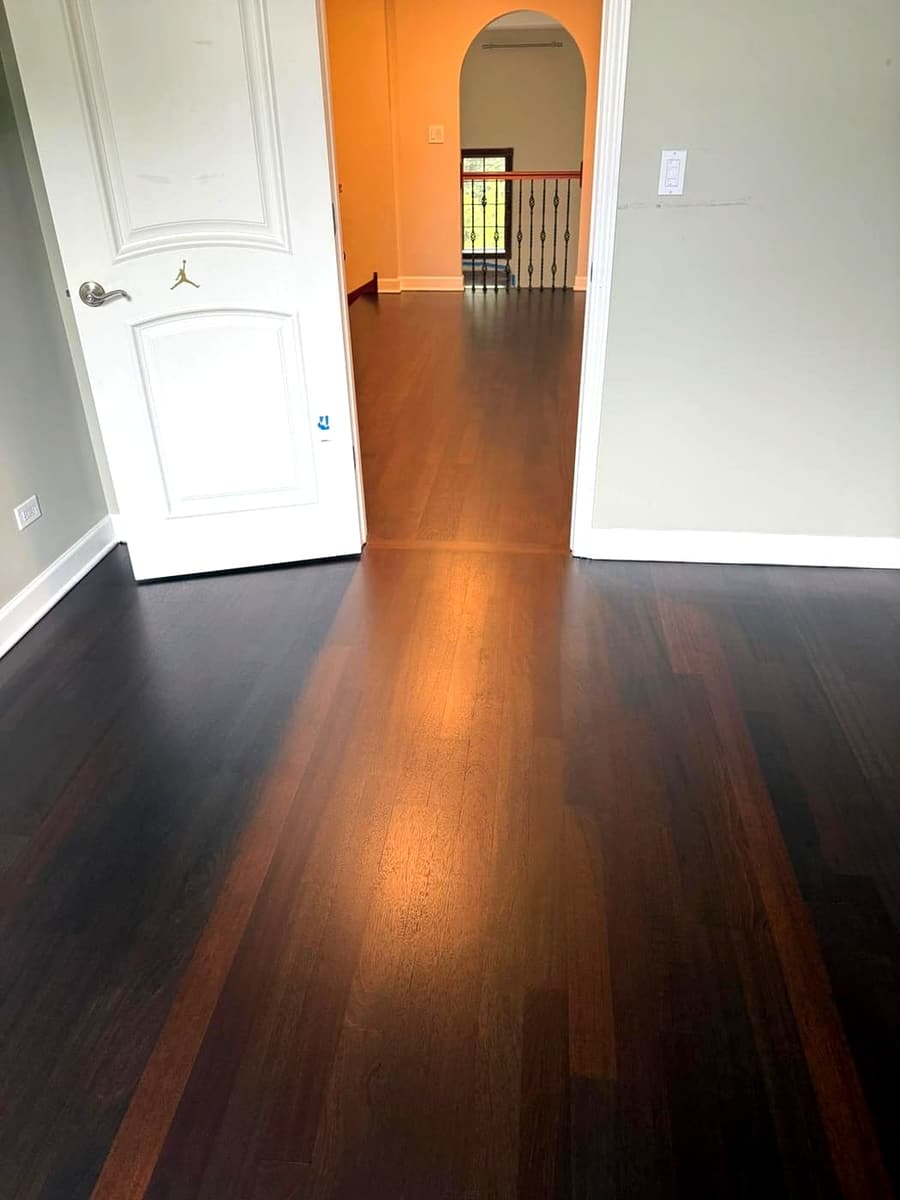 Two-tone hardwood floor with a medium-brown center path bordered by dark planks