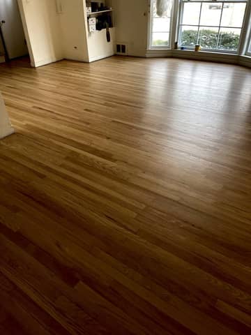 Natural sanded red oak floor in a living room with a bay window