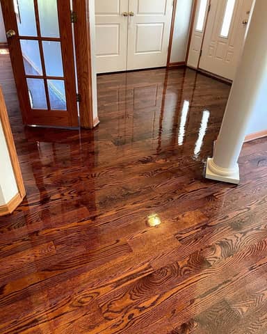 Freshly refinished red oak hardwood floor with a high-gloss finish in a home entryway
