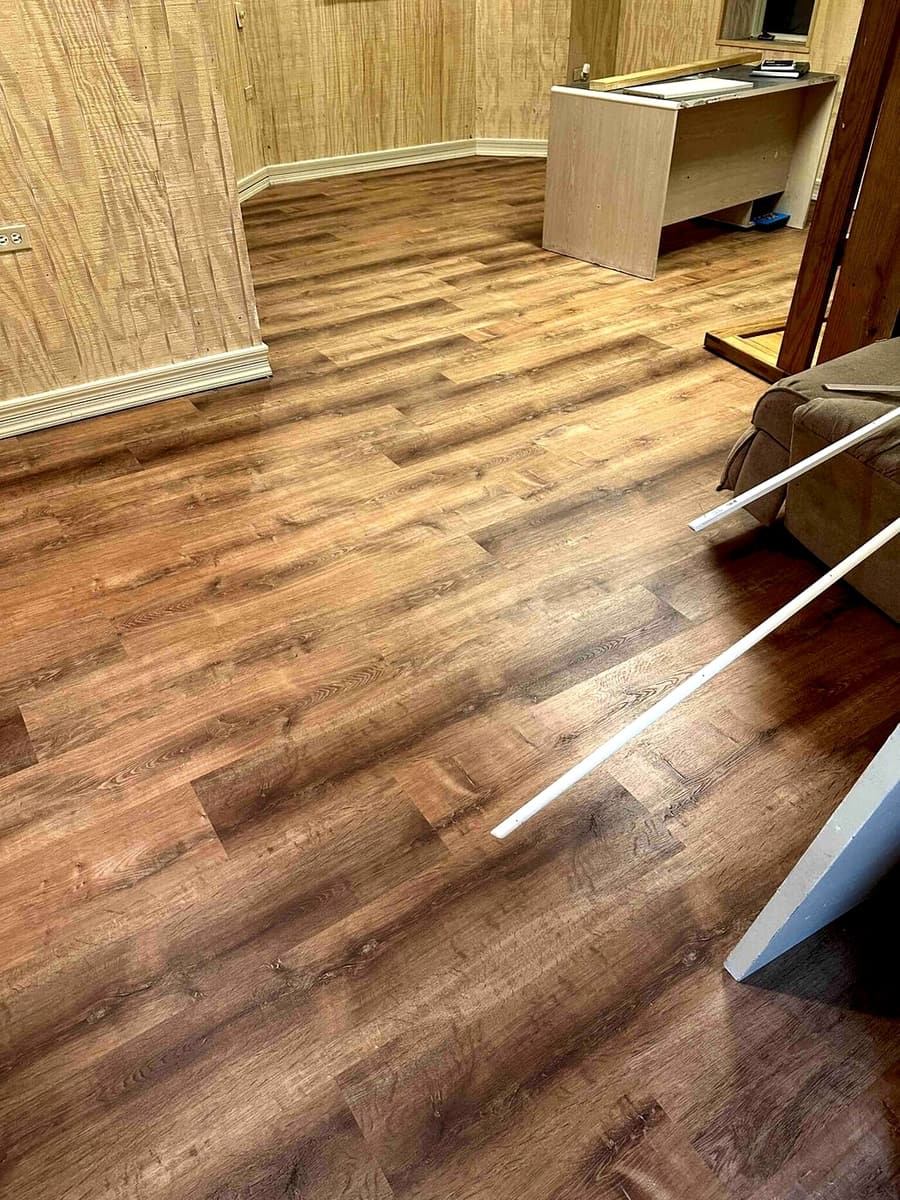 Wide-plank laminate flooring installed in a finished basement room